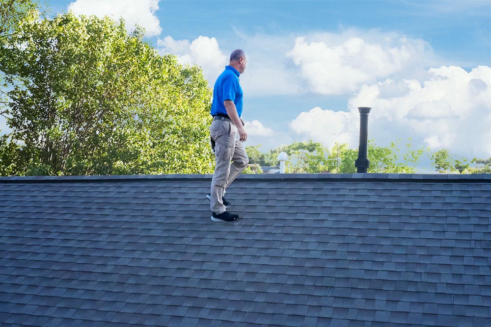 Craig on the roof of a house preforming home inspection services 